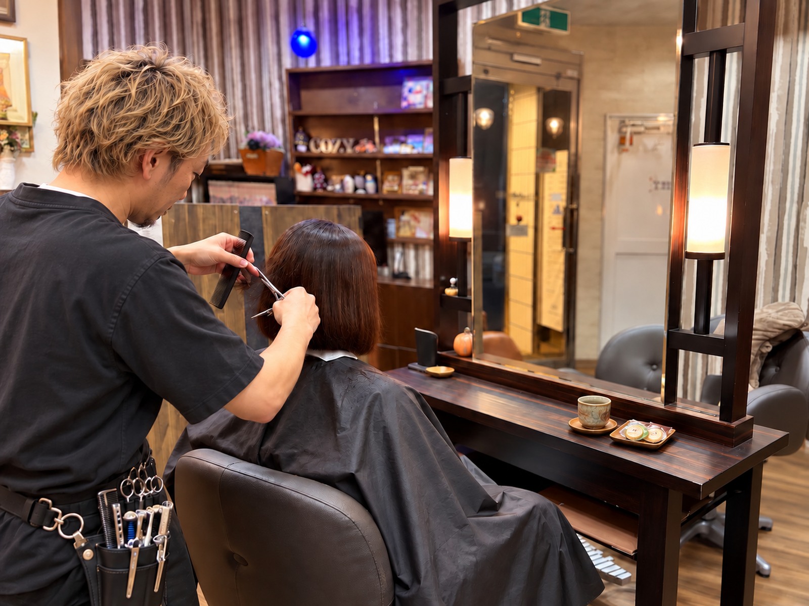 Hair Make Cozyの店内で美容師が丁寧に髪をカットしている風景